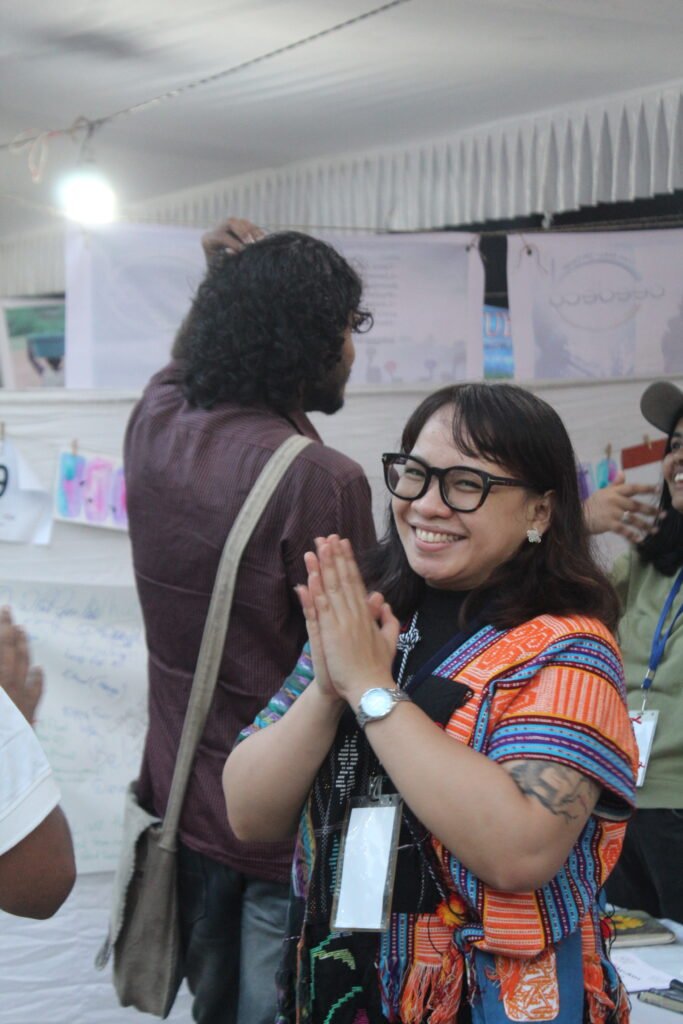 The founder of Talk Mental Health standing and her hands coming together in the front the chest with big smile